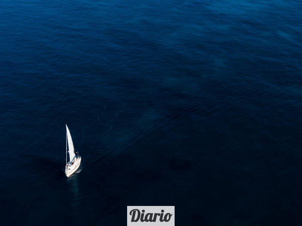 White Boat Sailing On Body Of Water